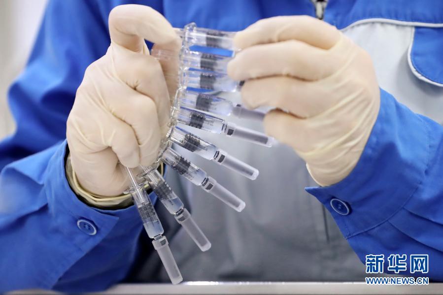 工作人员在科兴中维包装线上检查新冠病毒灭活疫苗预充注射器剂型上的标签 ...