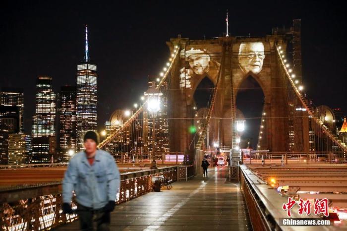 新冠肺炎去世的患者面容投影在布鲁克林大桥桥身上
