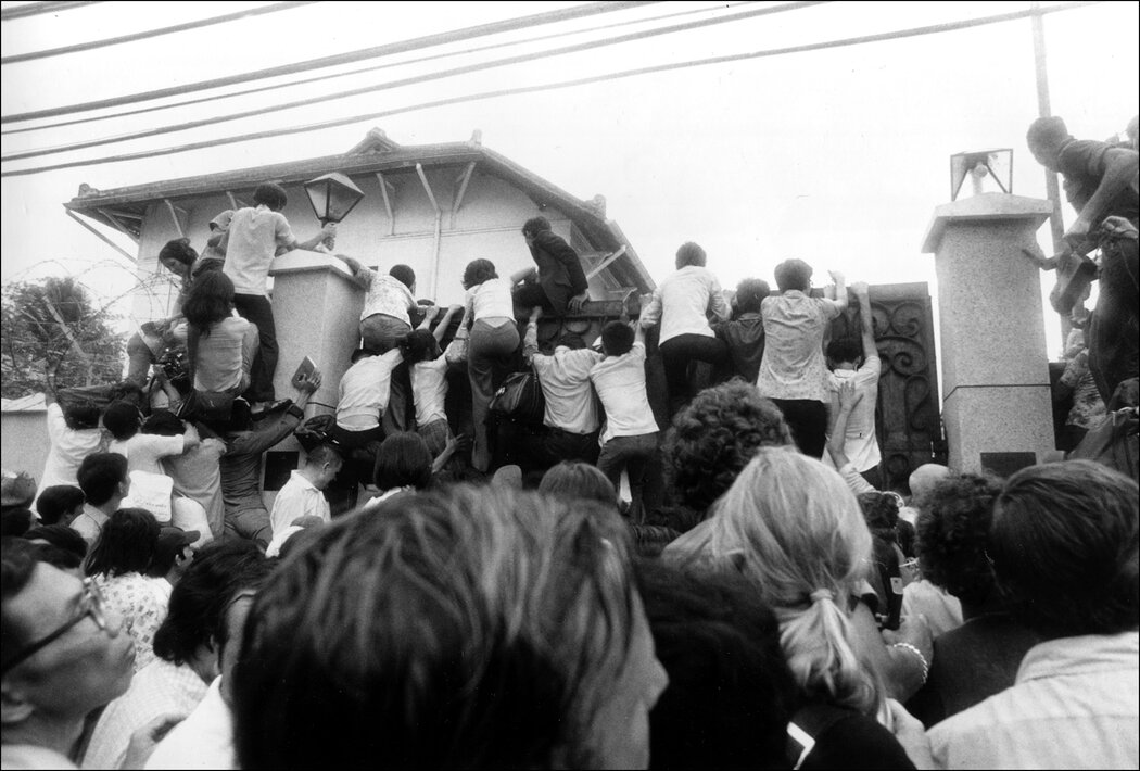 南越平民爬上美国大使馆的围墙