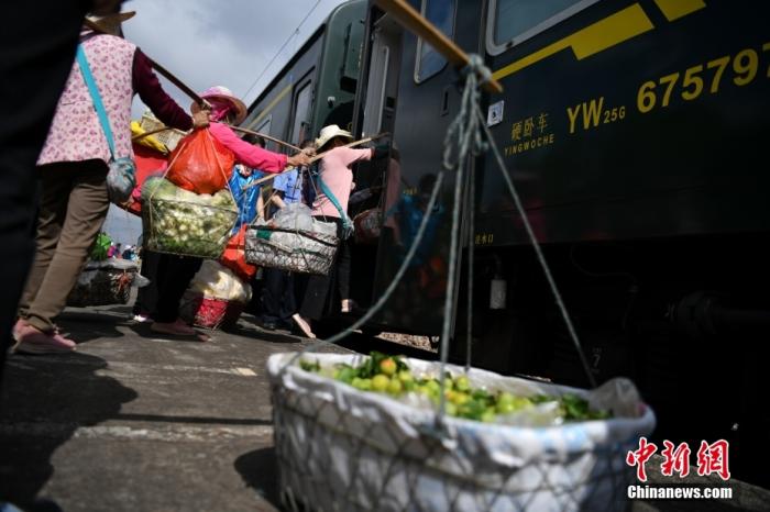 准备前往曲靖卖菜的村民在吴官田站登上云南昆明至贵州红果的5652次列车