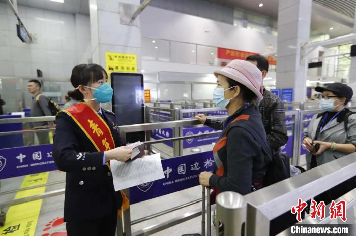 民警对首批出境旅行团进行证件查验